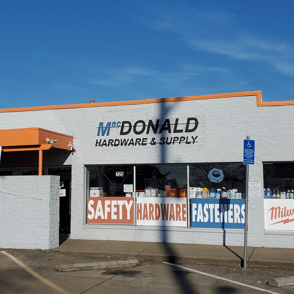 The MacDonald storefront, with window signs for safety, hardware and fasteners